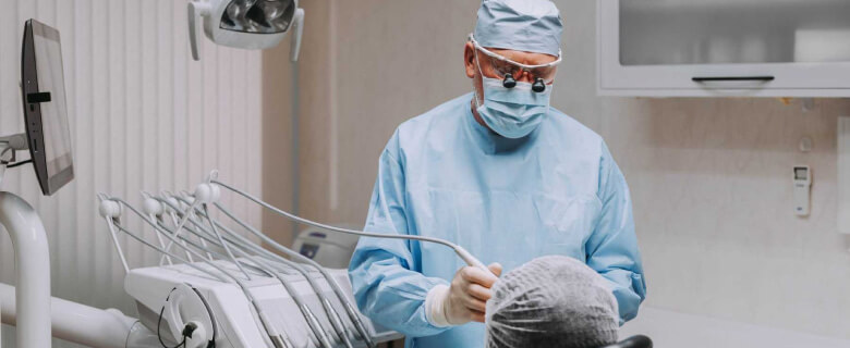 На изображении стоматолог совершает процедуру по удалению зуба, Евродент фото