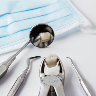 На изображении лежат инструменты стоматолога для удаления зубов и сам зуб, который уже вырвали, Евродент фото