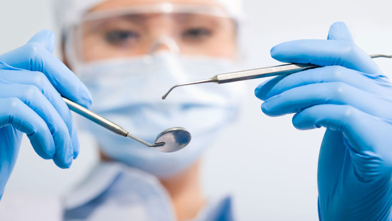 На изображении, стоматолог-хирург держит в руках инструменты